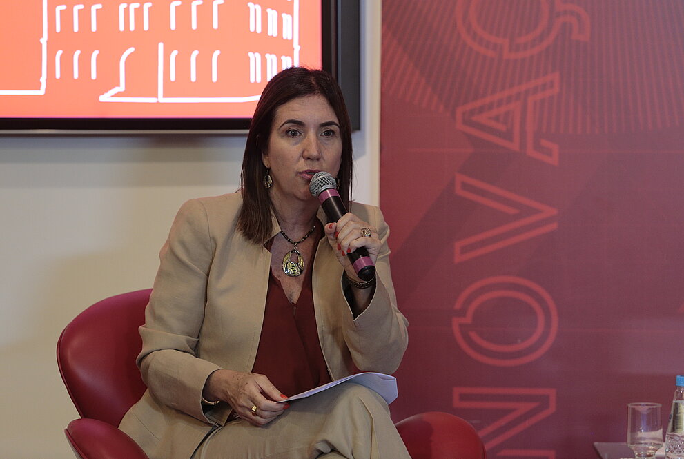 mulher sentada com um microfone na mão