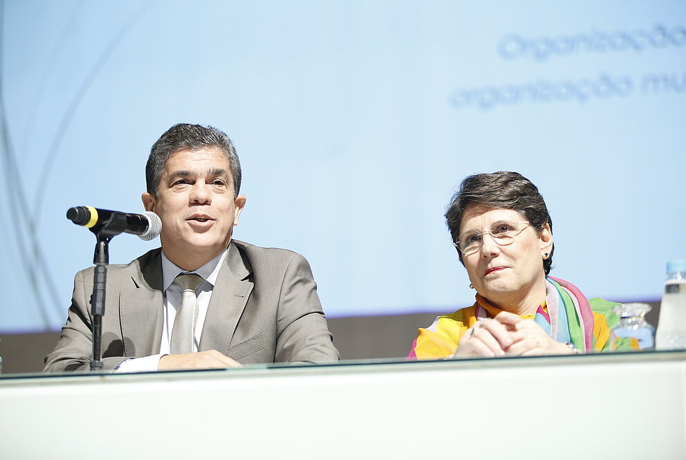 vice-reitor e diretora do CCBS sentados à mesa durante apresentação