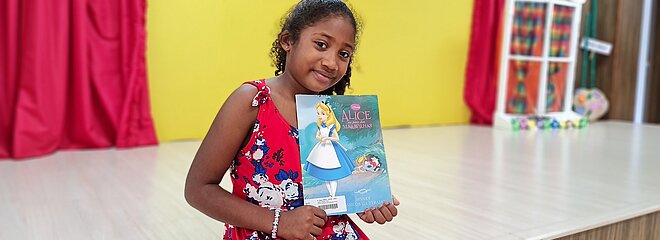 Aluna do Mackenzie Maria Júlya com um livro na mão