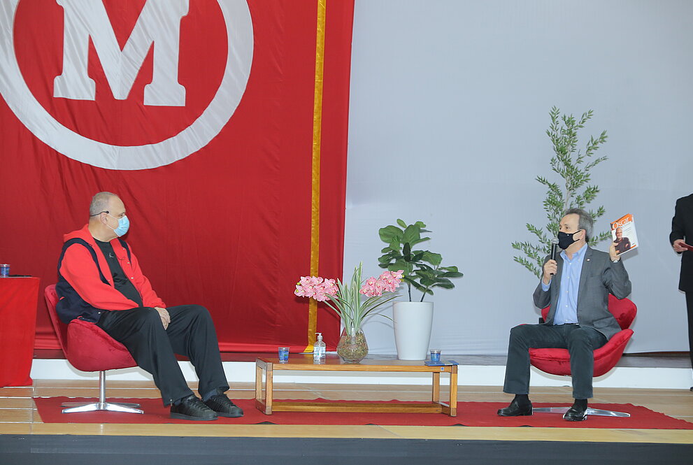 Dois homens assentando conversando 