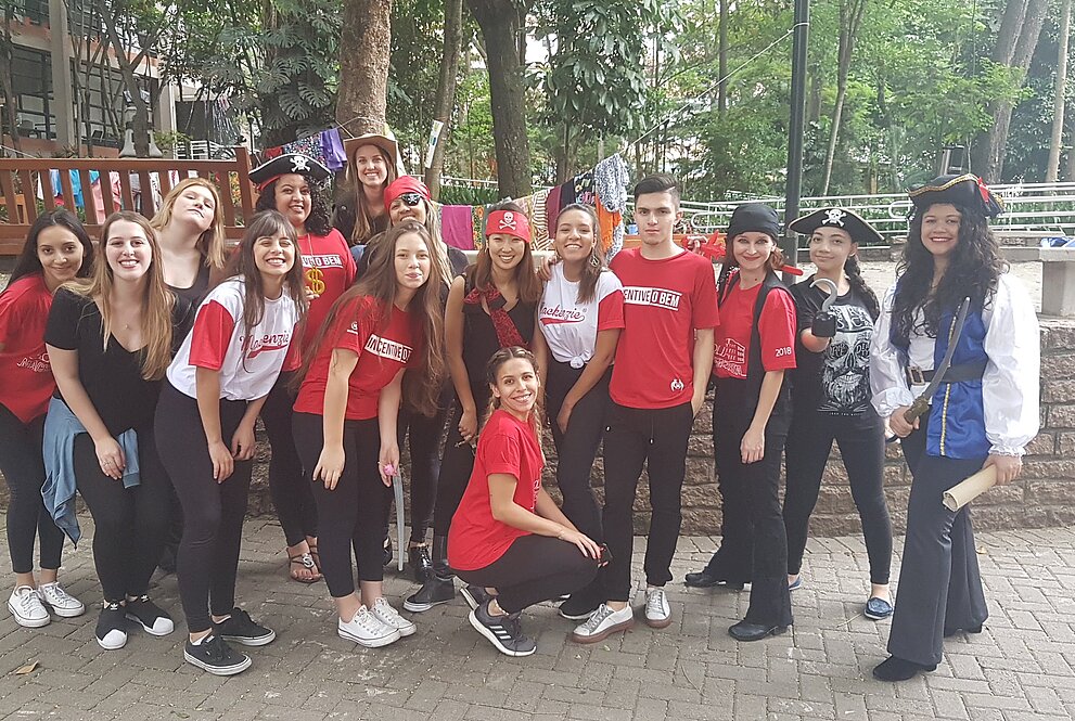 Grupo de jovens em pé e sorridentes