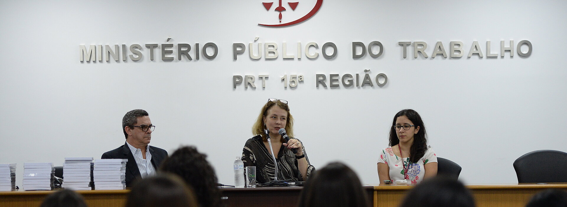 Ministério Público do Trabalho com três pessoas na mesa.