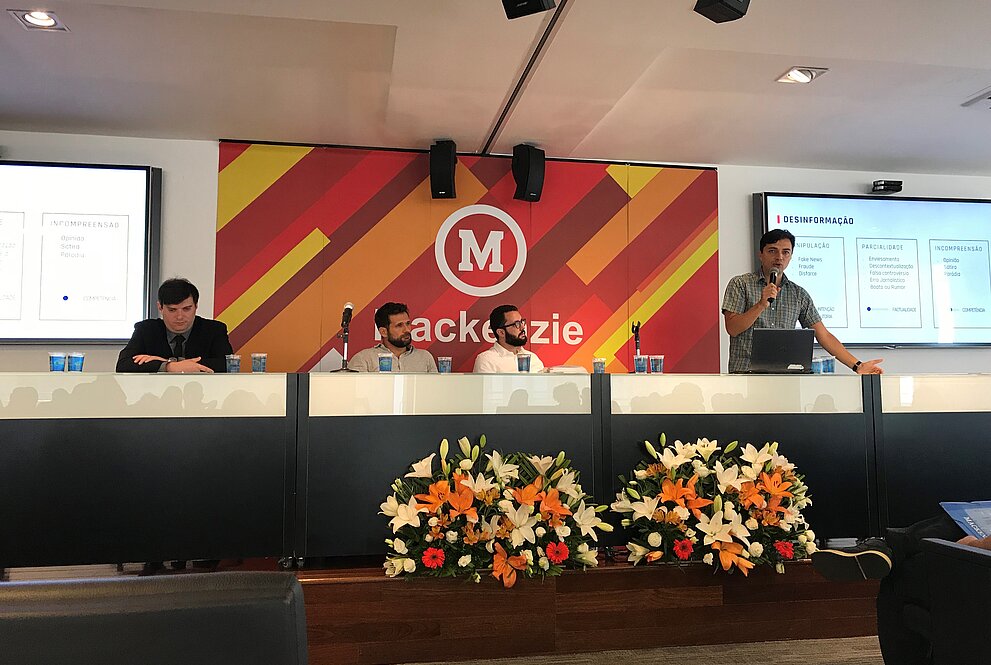 apresentadores compondo a mesa do evento