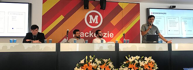 apresentadores compondo a mesa do evento