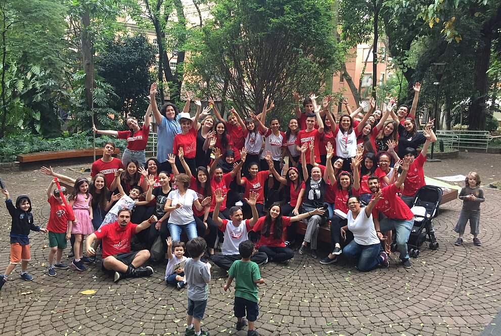grupo de pessoas que participaram da atividades com as mãos para o alto em comemoração