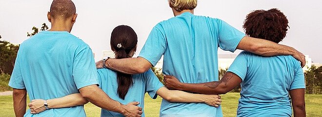 quatro pessoas de costas abraçadas
