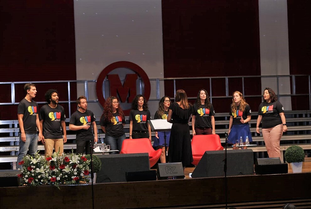 Pessoas do coral durante performance no palco do auditório Ruy Barbosa