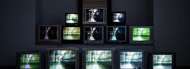 A imagem contém treze TVs uma próxima da outra