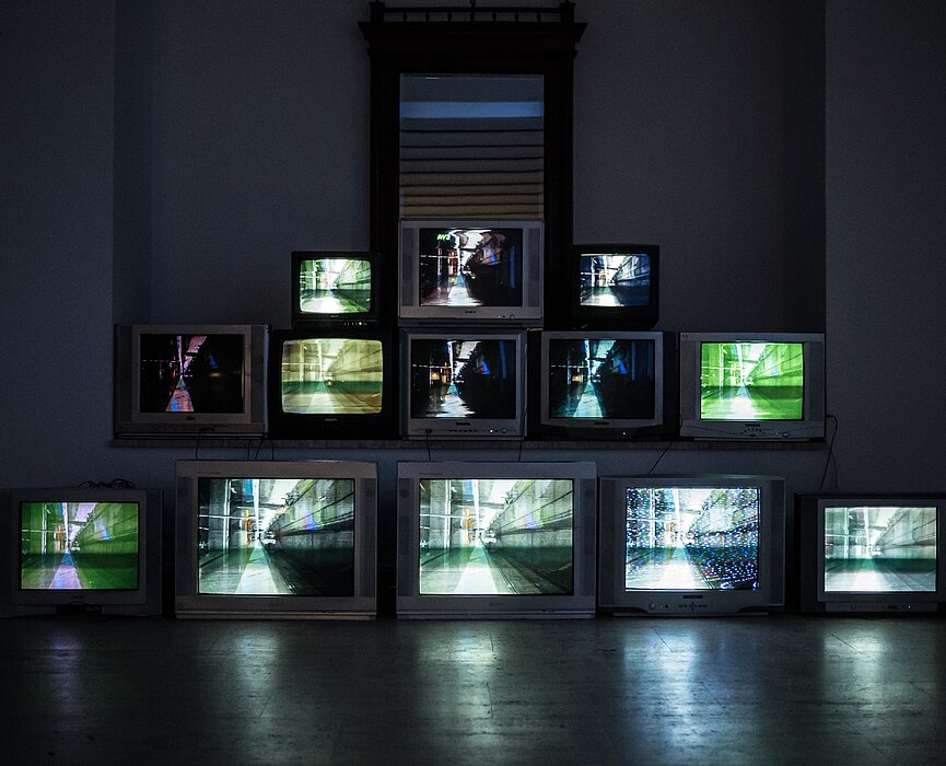 A imagem contém treze TVs uma próxima da outra