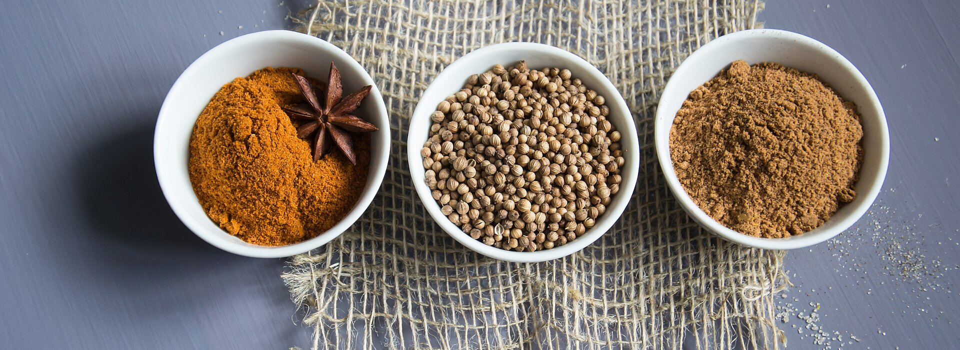 Três tipos de ingredientes espalhados em potes brancos 