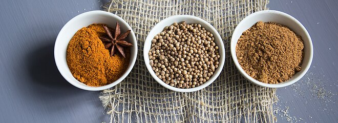 Três tipos de ingredientes espalhados em potes brancos 