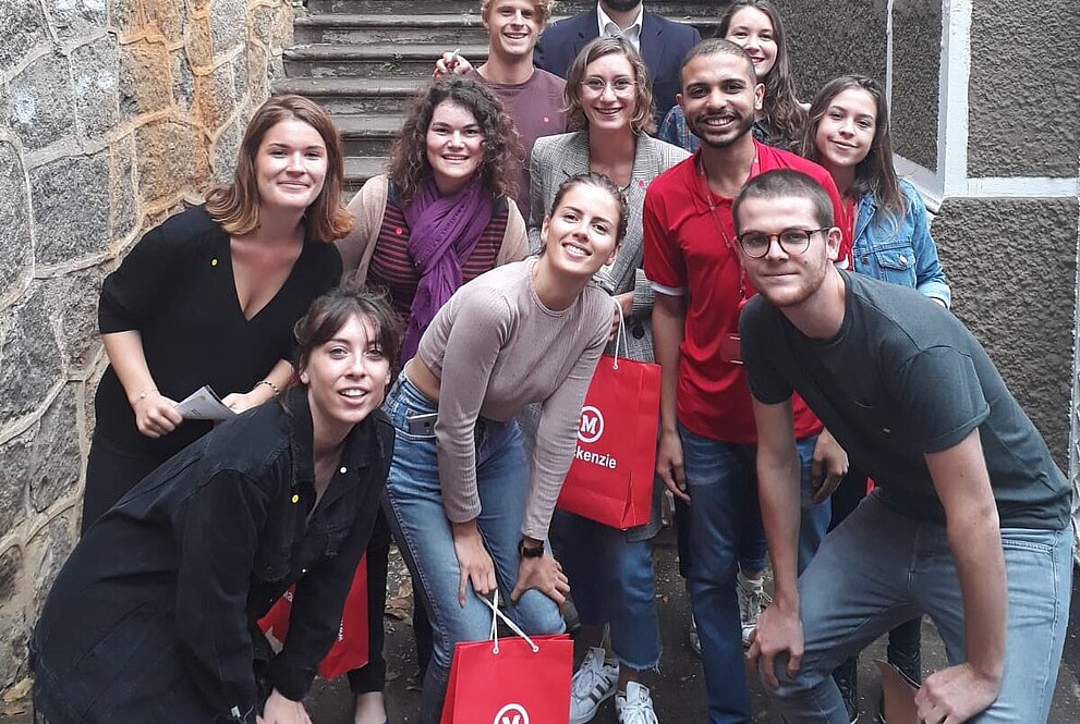 Professores e alunos reunidos nas escadarias do campus
