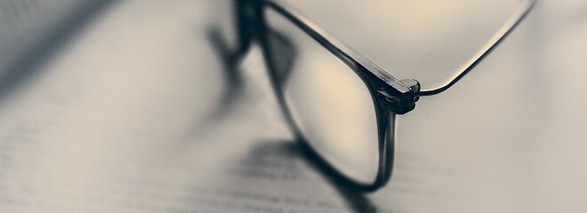 óculos sobre páginas de livro