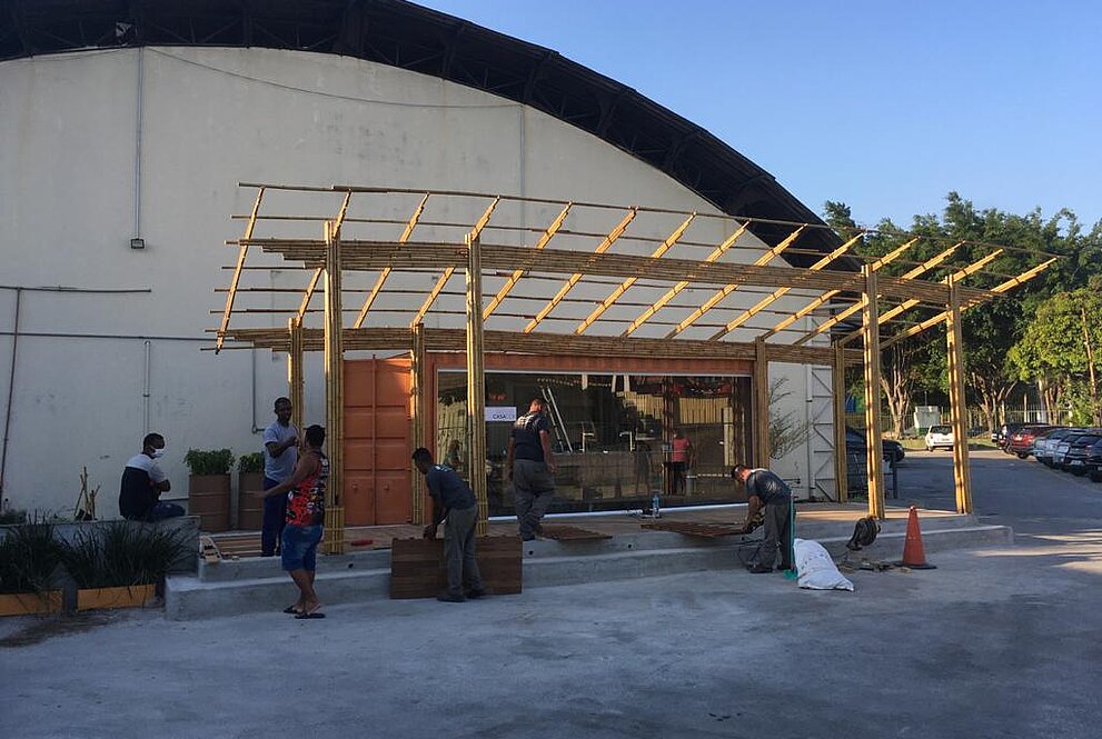 Na foto, ainda no começo da obra, homens trabalham na construção da cozinha comunitária. 