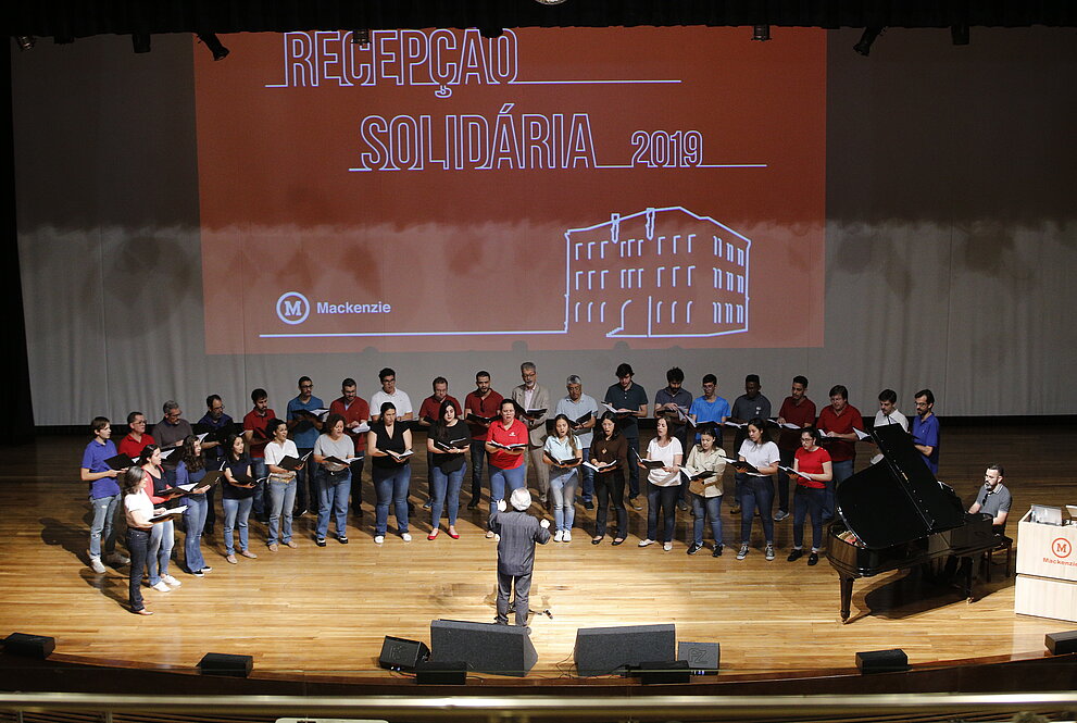 coral ao palco com telão ao fundo