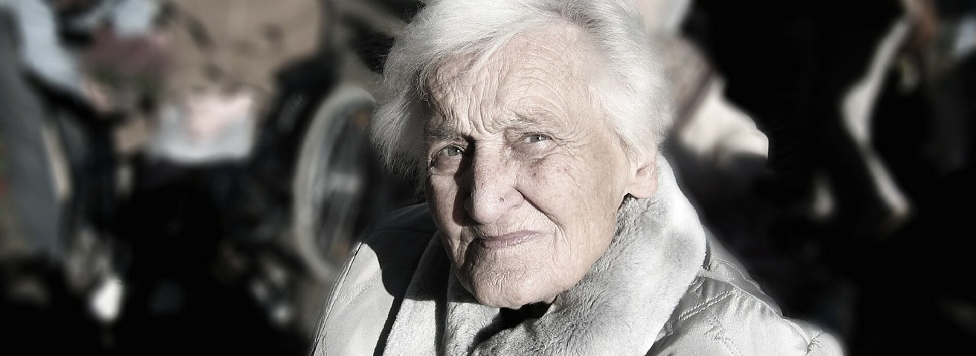 Na foto, mostra uma senhora olhando para a câmera