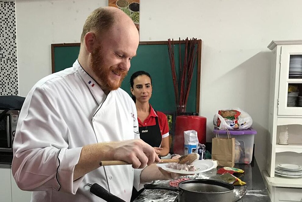 Arthur Sauer colocando a comida pronta no prato 