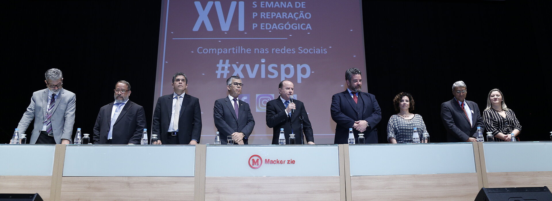Pessoas em pé, ao lado uma da outra