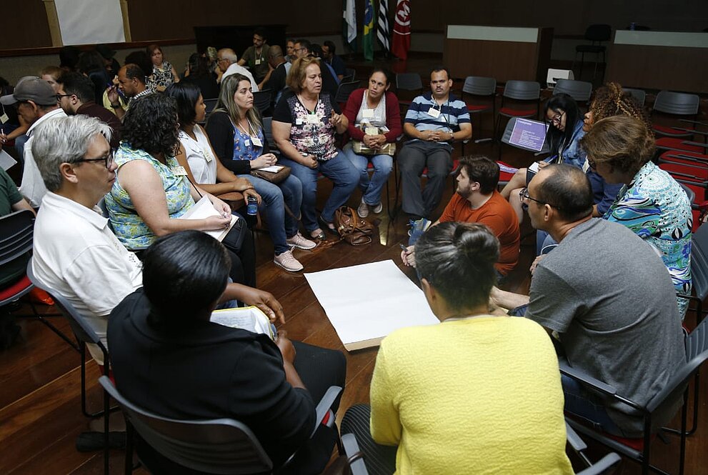 pessoas sentadas em formato de roda conversando