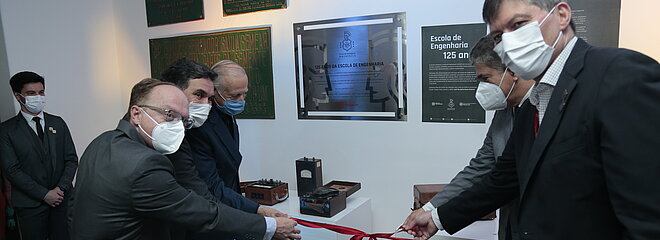 As autoridades seguram a fita para desenlaçar e inaugurar a exposição. 