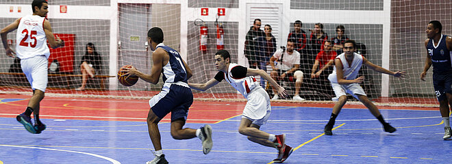 Jogadores do Mackenzie e da Escola Naval disputando basquete. 