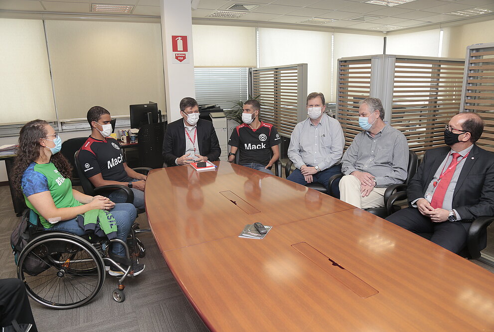 pessoas sentadas próxima à mesa oval 