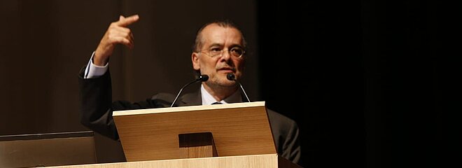 Gustavo Franco atrás do púlpito em sua palestra no auditório Ruy Barbosa