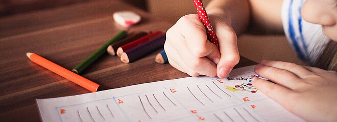menina desenhando em papel com lápis coloridos