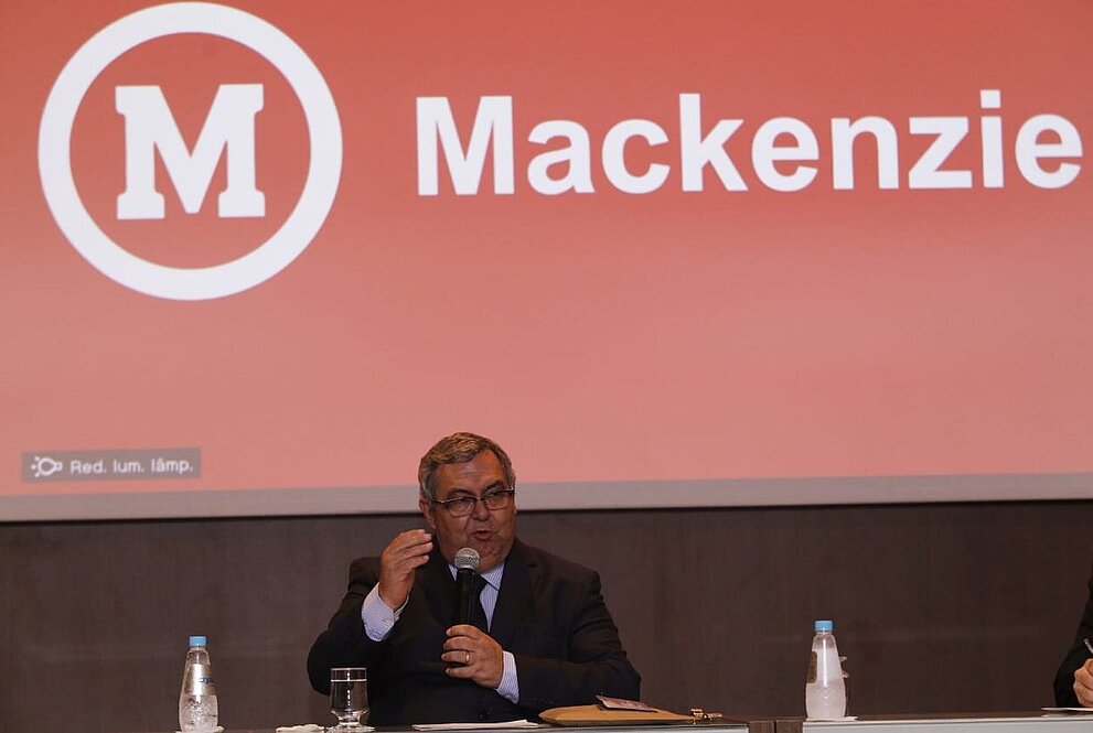 Roberto Brasileiro sentado à mesa discursando