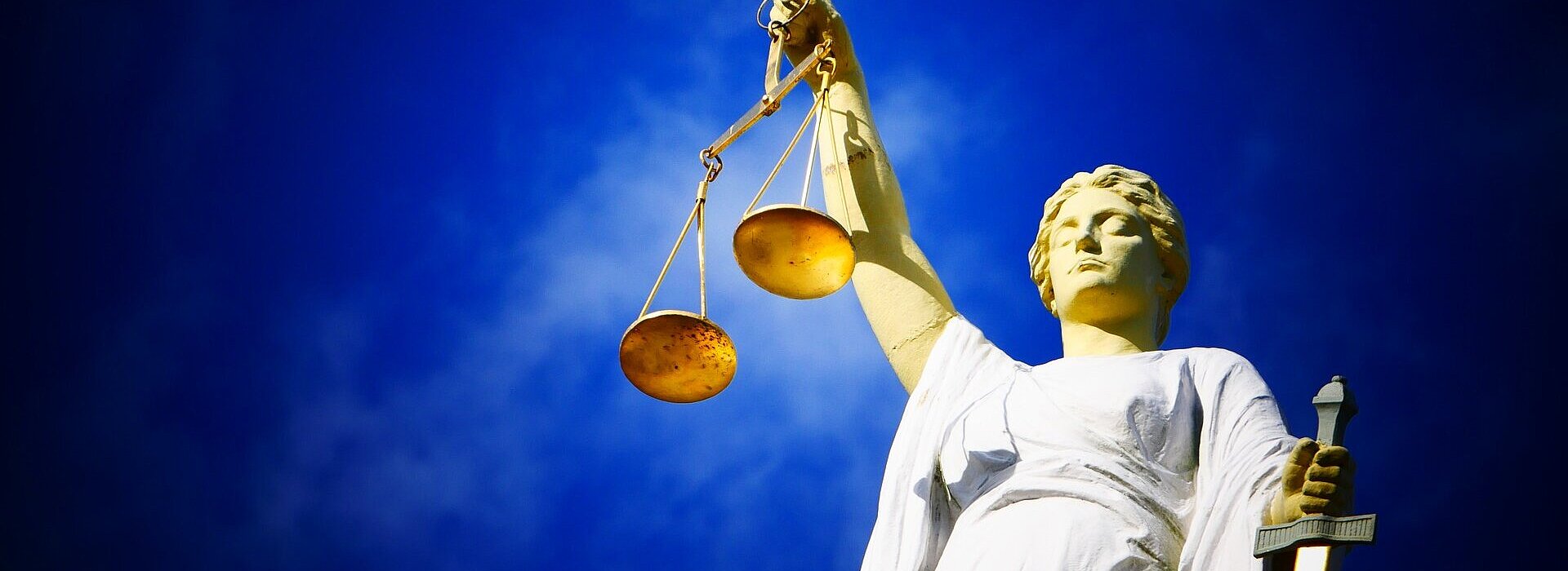 Imagem de uma estátua segurando uma balança, objeto símbolo do julgamento.