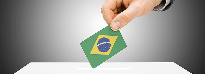 mão coloca voto com bandeira do Brasil em urna