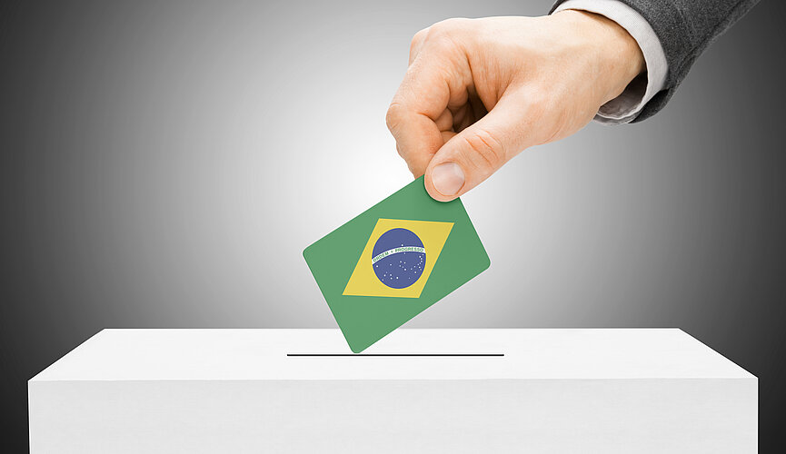 mão coloca voto com bandeira do Brasil em urna
