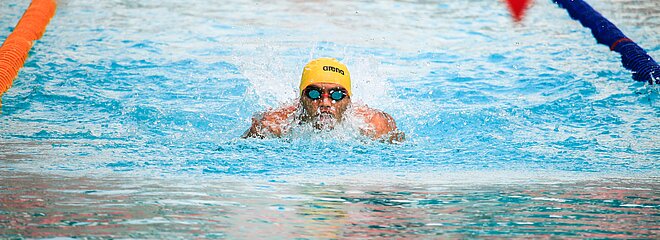 Nadador treinando em piscina olímpica. 