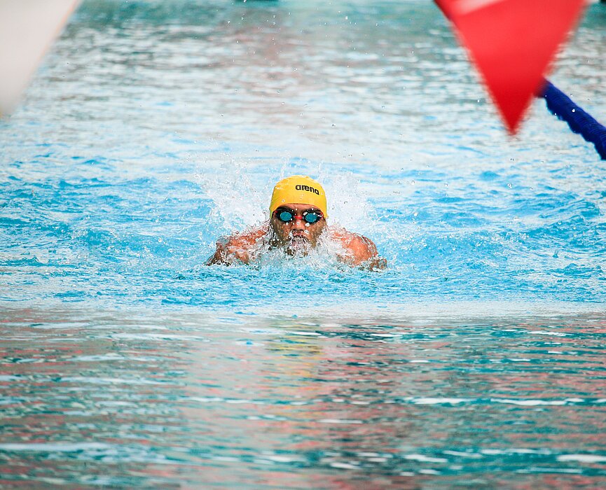 Nadador treinando em piscina olímpica.