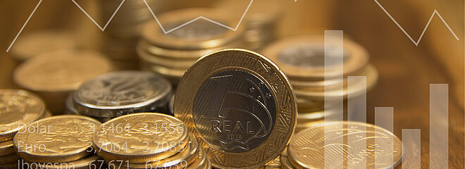 Moedas de real empilhadas sobre mesa de madeira
