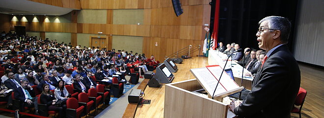 auditório cheio e mesa de autoridades