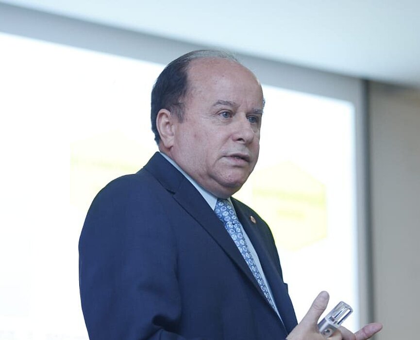 reitor da Universidade Presbiteriana Mackenzie aparece em frente ao data show, durante sua apresentação da palestra