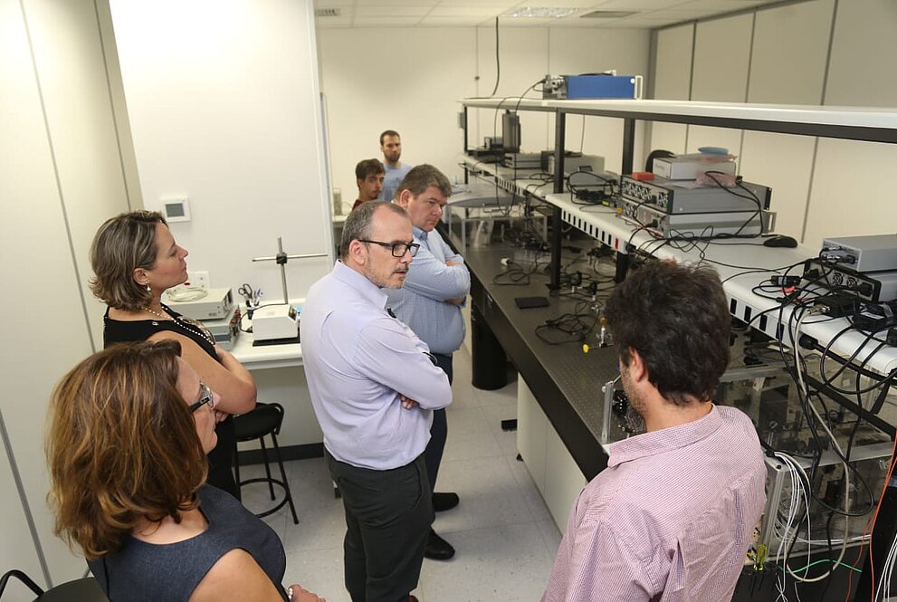 Cinco pessoas observam equipamento eletrônico no laboratório do Mackenzie