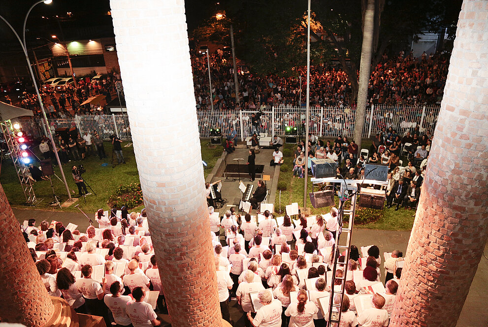 Visão do alto do seminário do coral e da população na rua. 