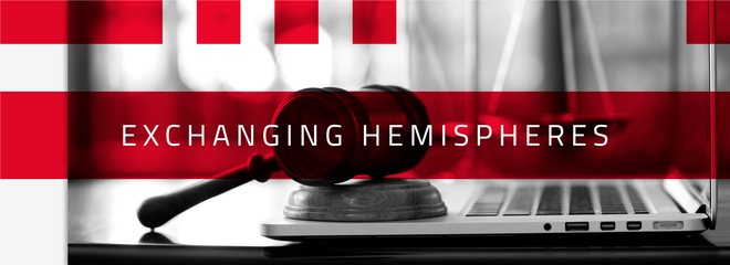 A imagem mostra em destaque o nome do programa "Exchanging Hemispheres" com detalhes em vermelho e uma foto em preto e branco na parte de trás, com um martelo do juiz, conhecido como malhete, em cima de um notebook. Ao fundo, bem desfocado, está a balança - símbolo do curso de direito. 
