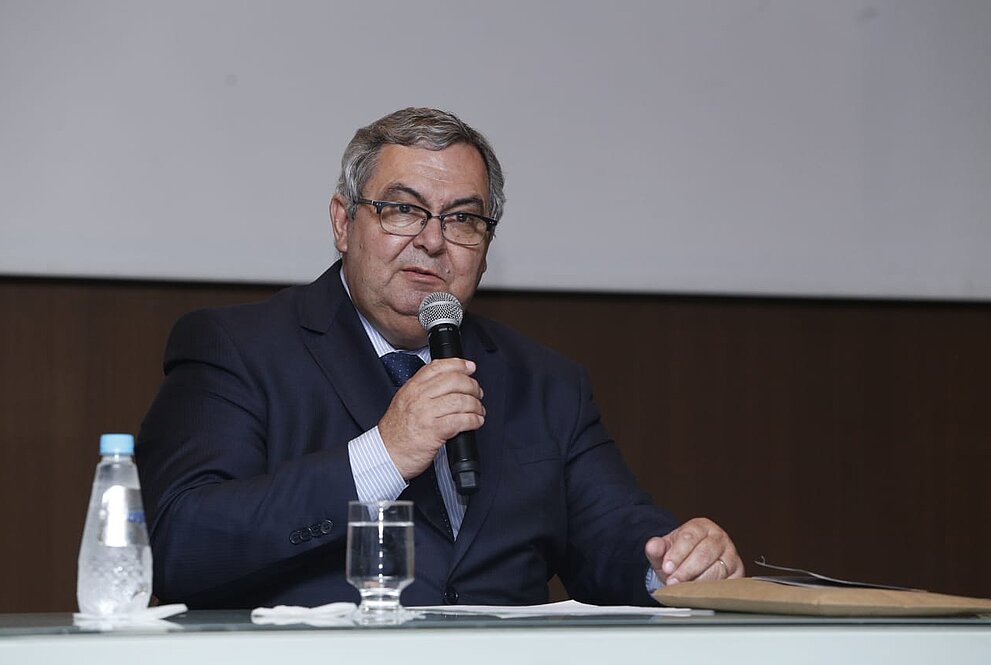 Roberto Brasileiro, com microfone sentado à mesa