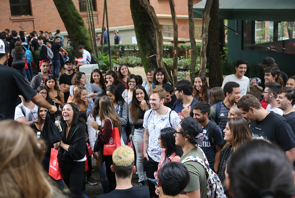 Novos alunos no campus recebendo brindes.