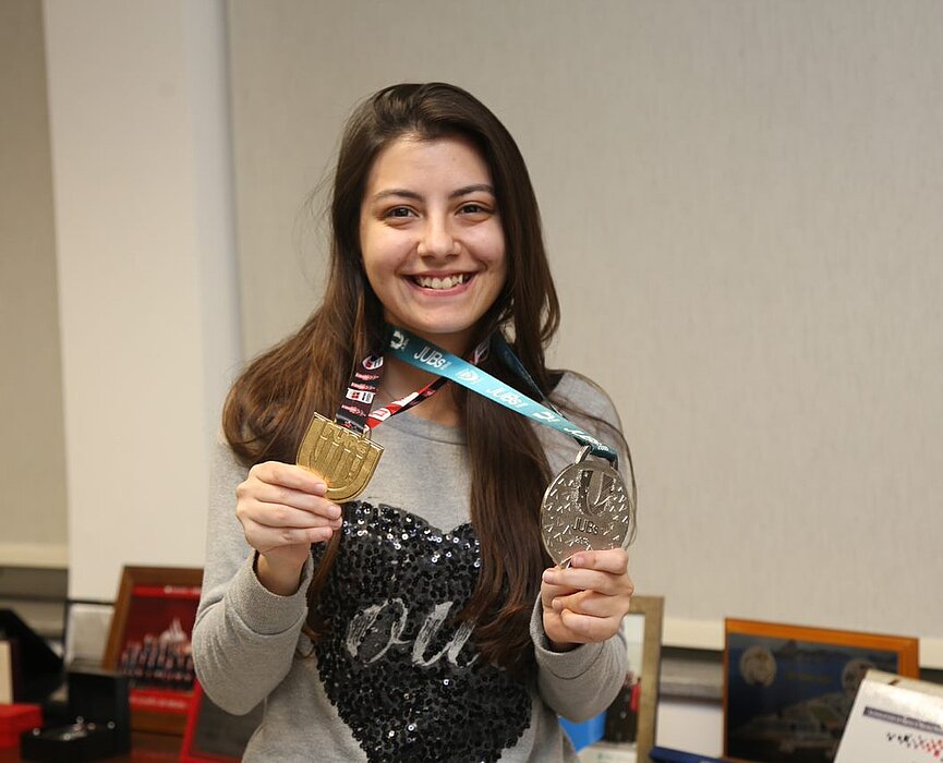 Júlia mostrando medalhas 
