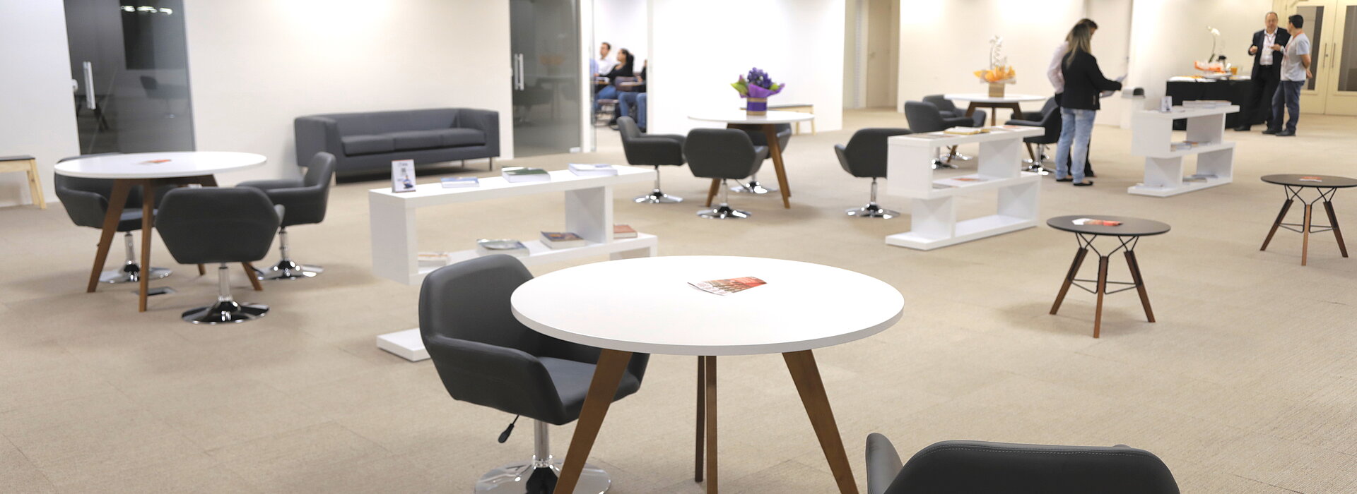 ampla sala com mesas e cadeiras para usos diversos