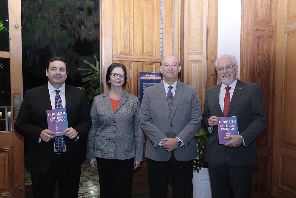 quatro pessoas em pé, mostrando livros 